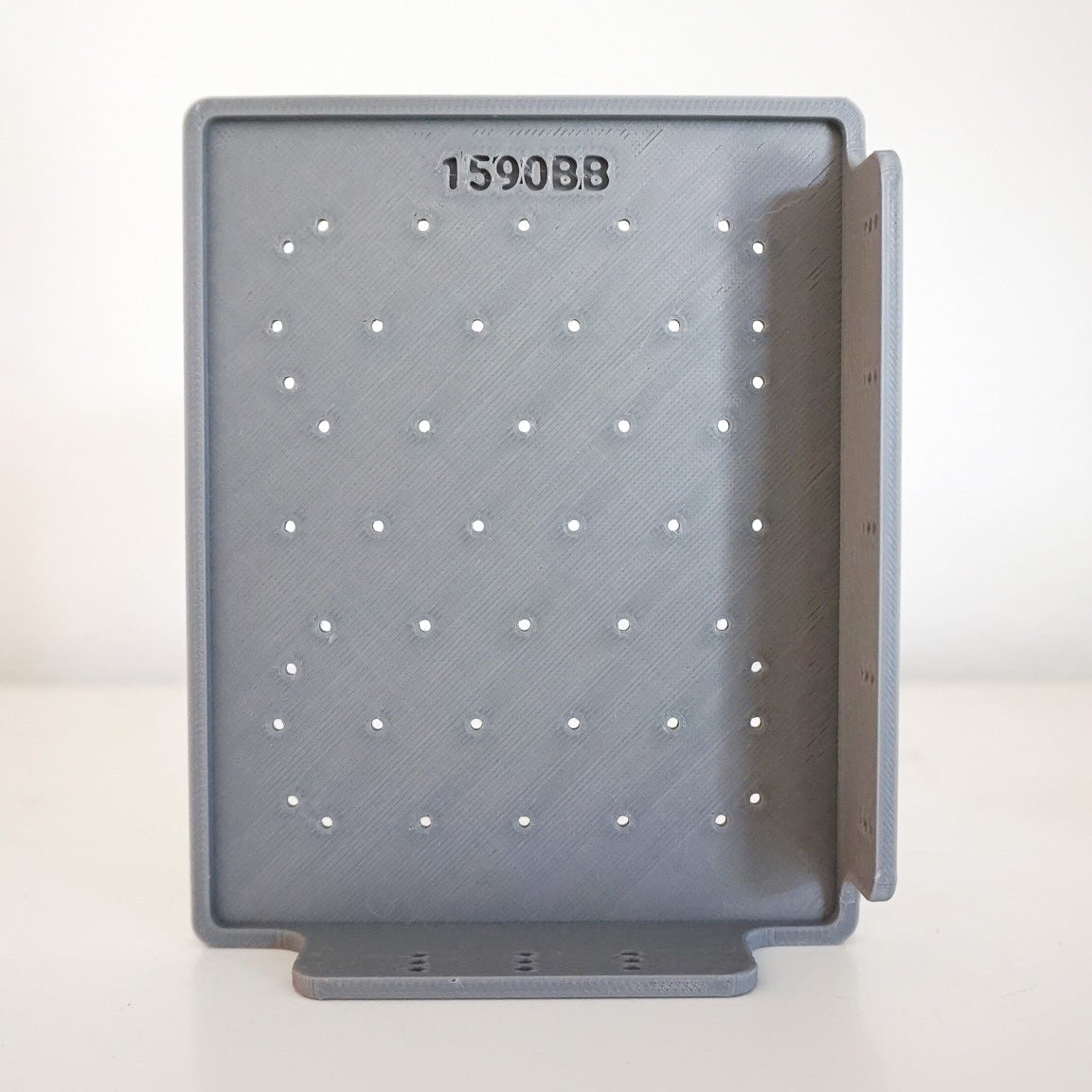 Gray perforated tray with a label on a white background