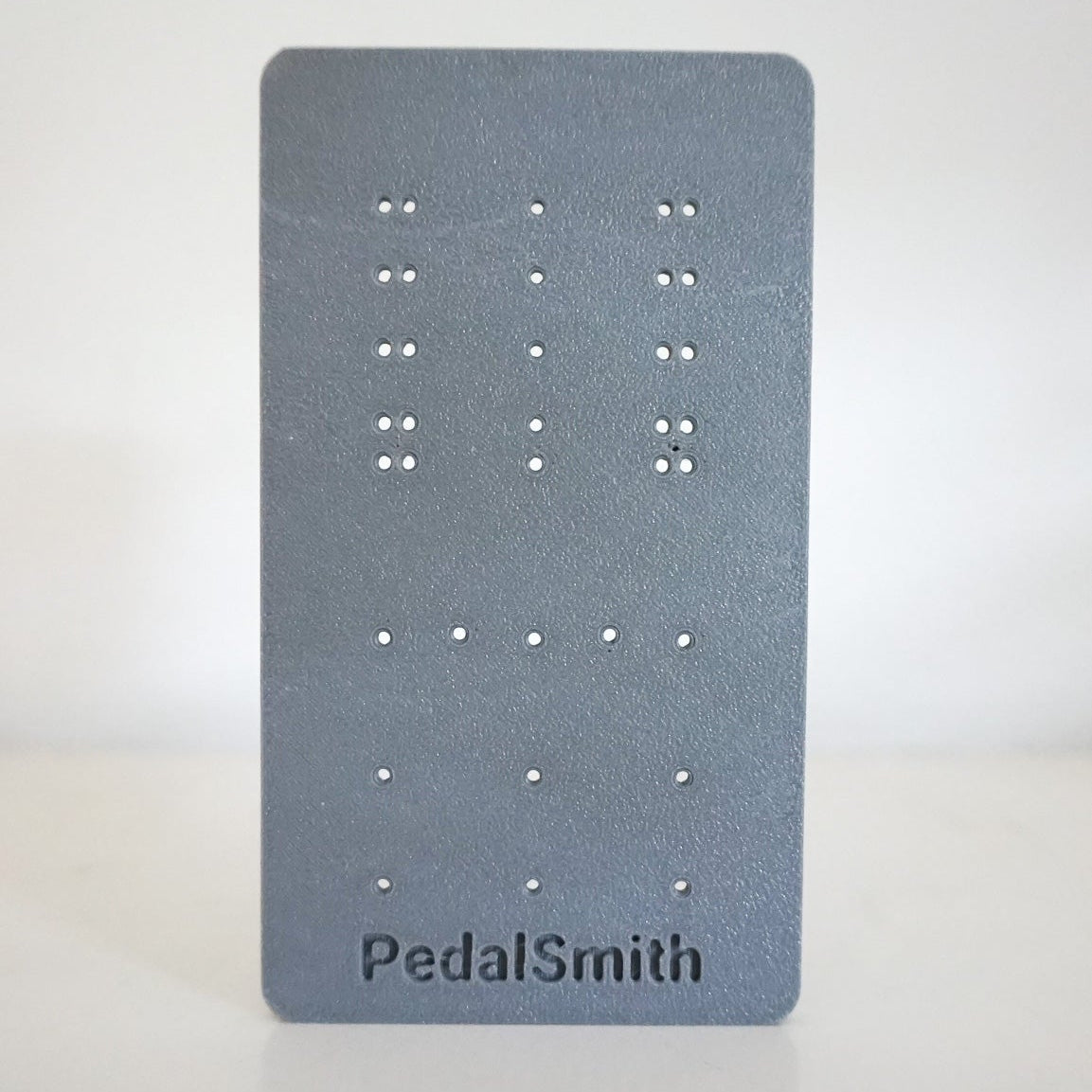Gray earring display card with 'PedalSmith' branding on a white background