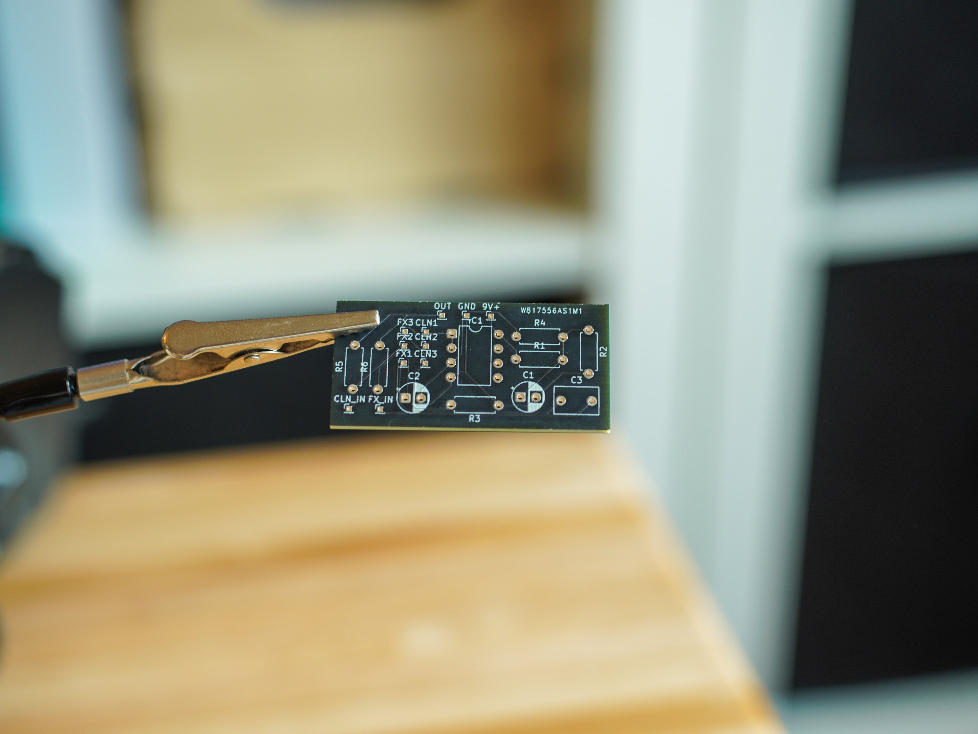 Close-up of a small electronic component on a wooden surface with a blurred background